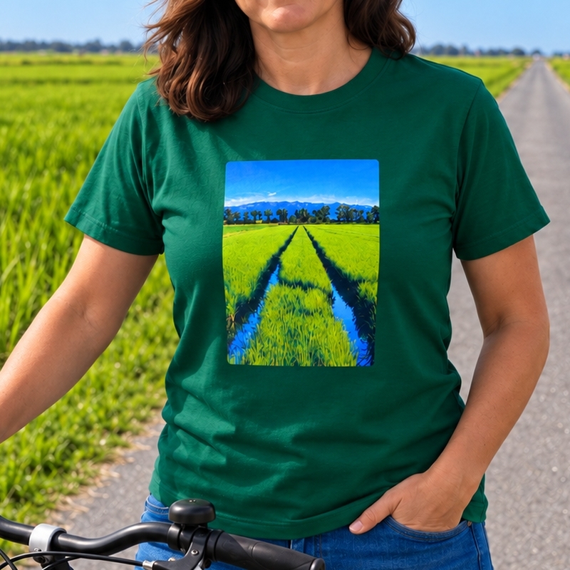 Dona amb la samarreta verda Foto Arrossar de Lo Fang Club, amb una fotografia d’un camp d’arròs del Delta de l’Ebre estampada al pit, al costat d’una bicicleta entre arrossars.