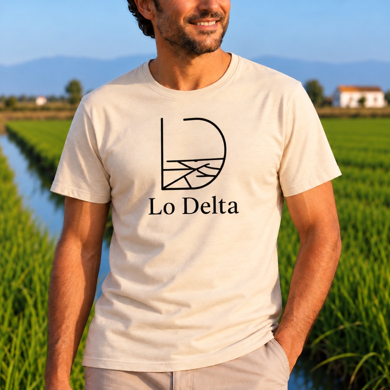 Primer pla d’un home amb la samarreta beix Lo Delta Style de Lo Fang Club, mostrant l’estampat negre Lo Delta amb línies que evoquen els arrossars i els canals del Delta de l’Ebre.