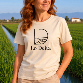 Primer pla d’una dona amb la samarreta beix Lo Delta Style de Lo Fang Club, amb el disseny negre Lo Delta inspirat en el paisatge del Delta de l’Ebre, amb els arrossars de fons.